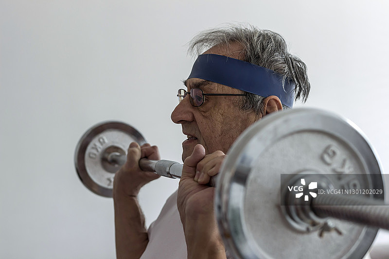 一个老年人在家锻炼的剪影。图片素材
