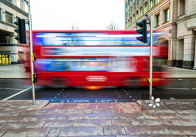 在城市中超速行驶的红色伦敦公共汽车的模糊运动图片素材