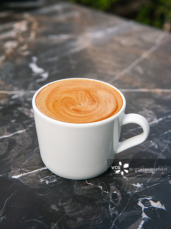 一杯加拿铁艺术的卡布奇诺咖啡。图片素材