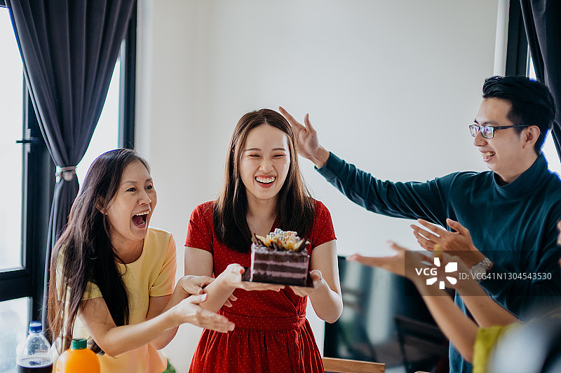 快乐的亚洲妇女庆祝她的生日和朋友在家里图片素材