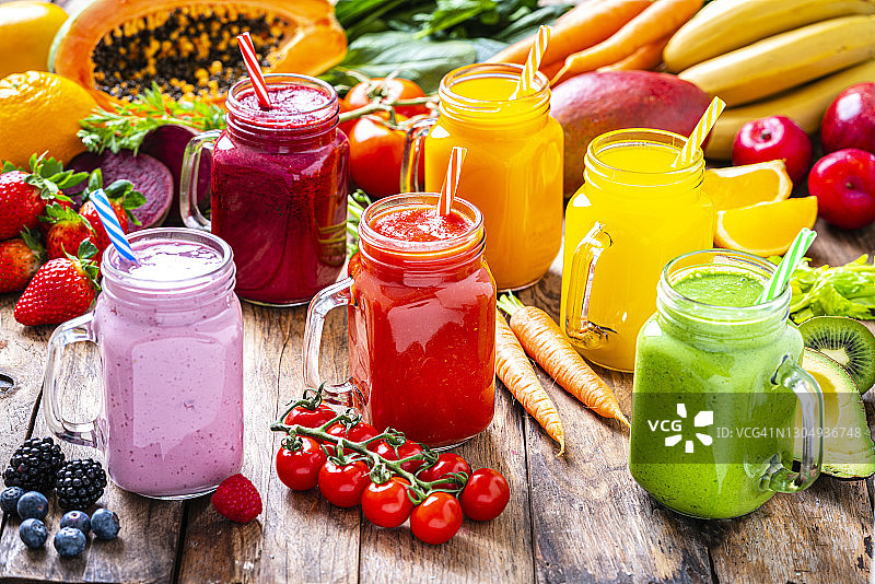 健康的彩虹色水果和蔬菜冰沙放在质朴的木桌上图片素材
