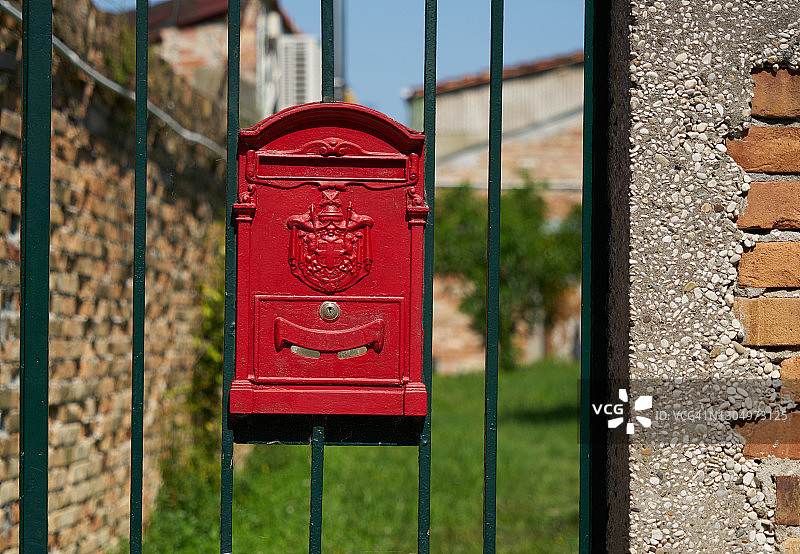 绿色篱笆上的红色邮箱图片素材