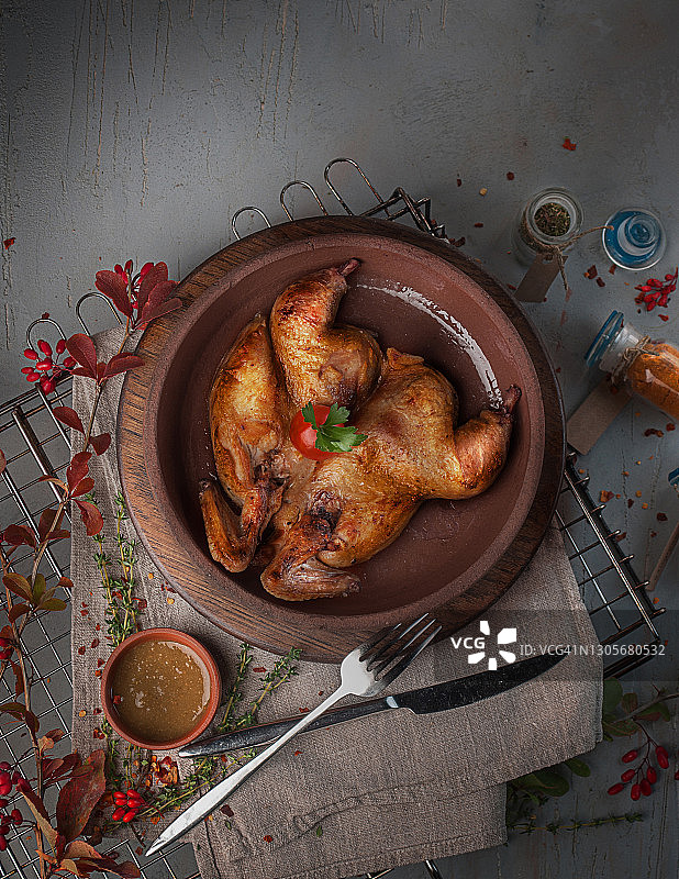 食物摄影的传统格鲁吉亚菜烤炸烤鸡Tabaka在木制板上俯视图，在一个灰色纹理的背景近距离图片素材