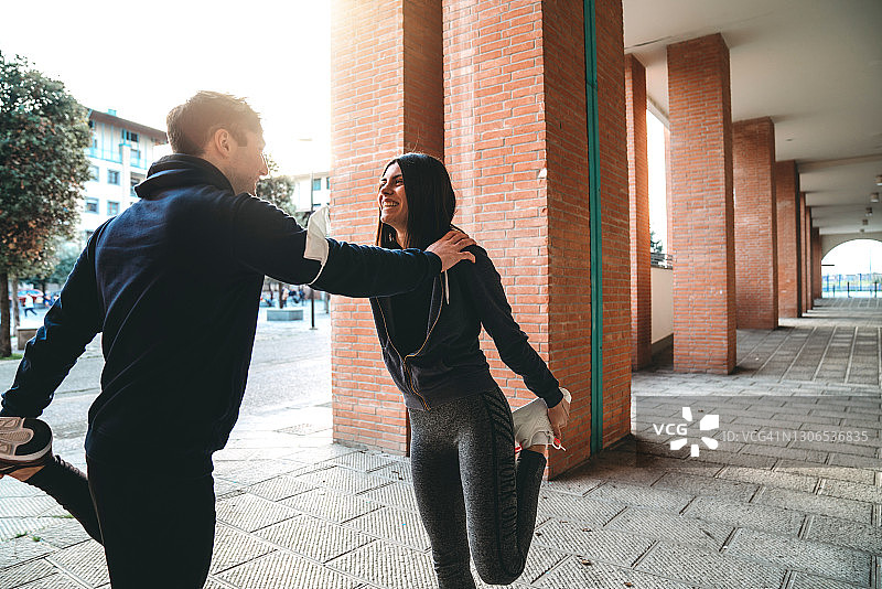 一对年轻夫妇在城市里做伸展运动图片素材