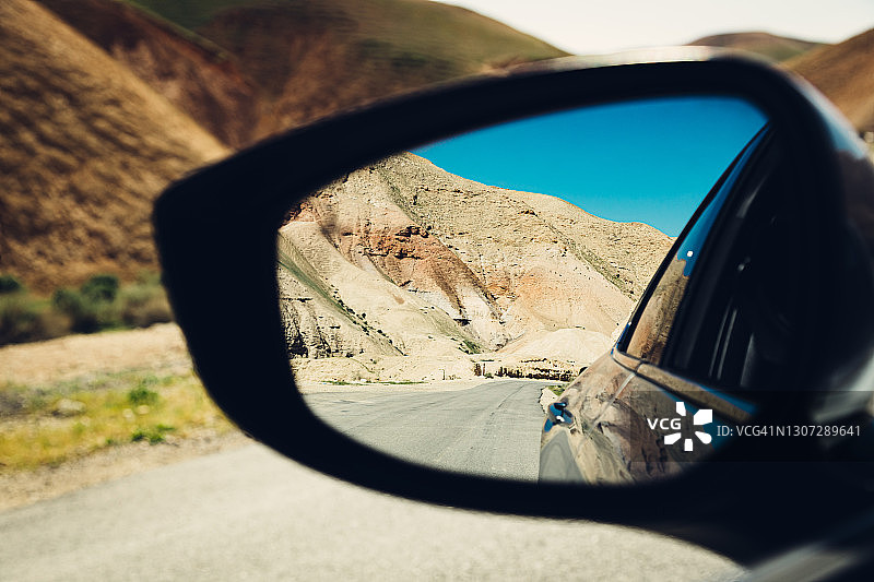在沙漠中旅行，侧视汽车后视镜图片素材