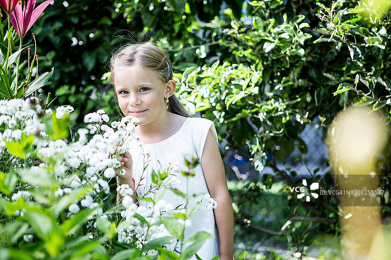 花园里有盛开的花朵的女孩。图片素材