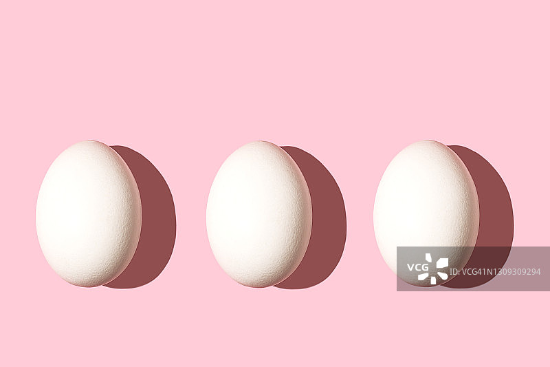 用白色复活节彩蛋做成的时尚图案，背景是淡粉色。图片素材