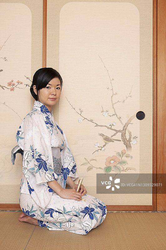 画像美丽的年轻日本妇女在和服在油漆门图片素材