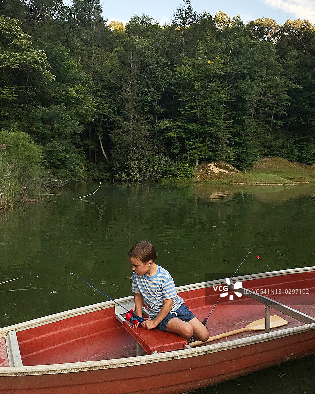 坐在独木舟里的小男孩图片素材