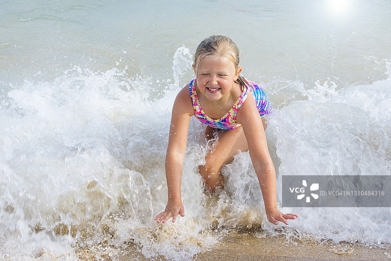 小女孩在沙滩上玩冲浪图片素材