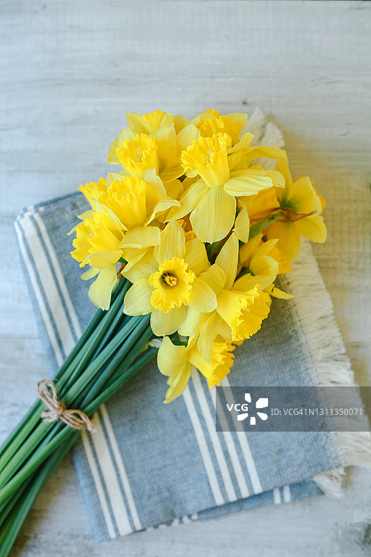 一束春天的黄色水仙花在灰色的乡村背景。春节贺卡，母亲节。图片素材