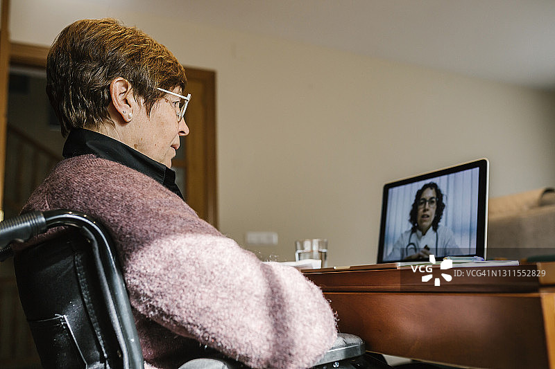 残疾资深女性在家与女医生视频通话图片素材