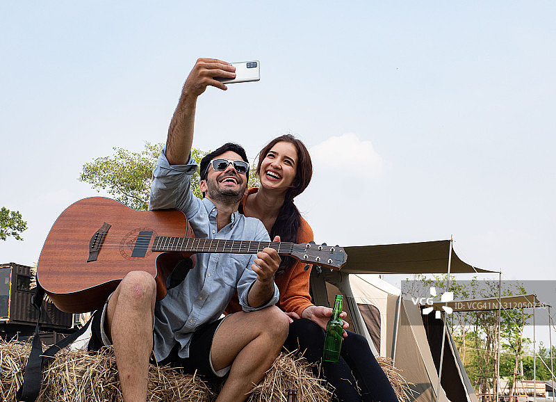 一对浪漫的情侣在露营时一起弹吉他唱歌图片素材