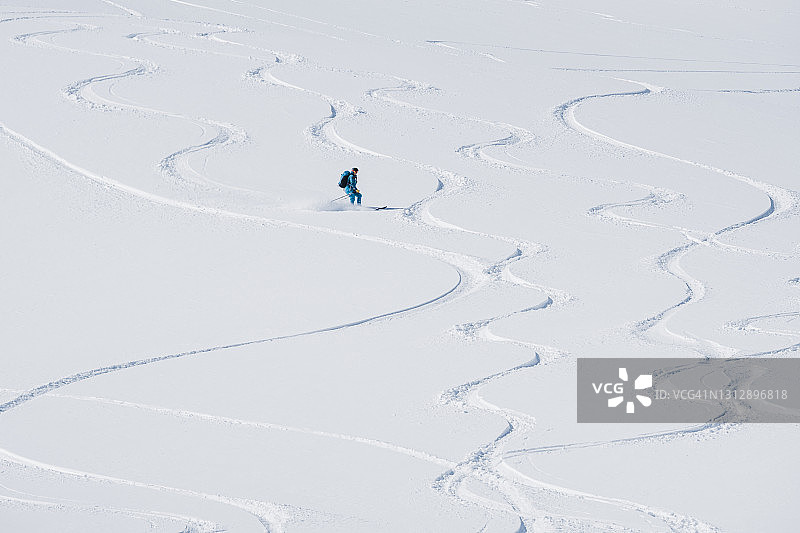 女滑雪者下有许多滑雪道的斜坡图片素材