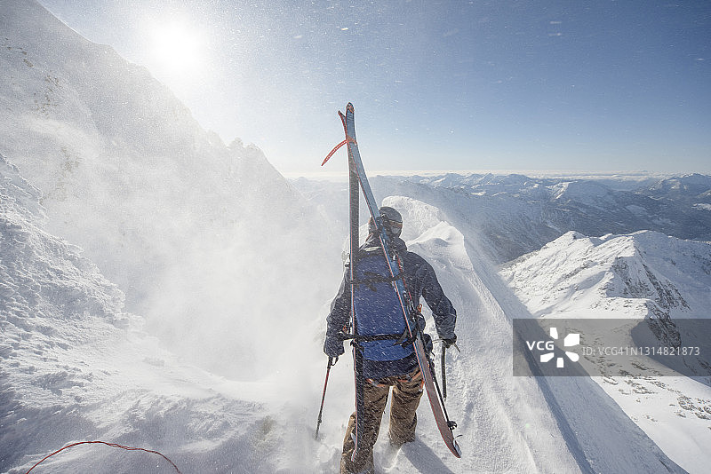 滑雪登山运动员攀登积雪的山峰图片素材