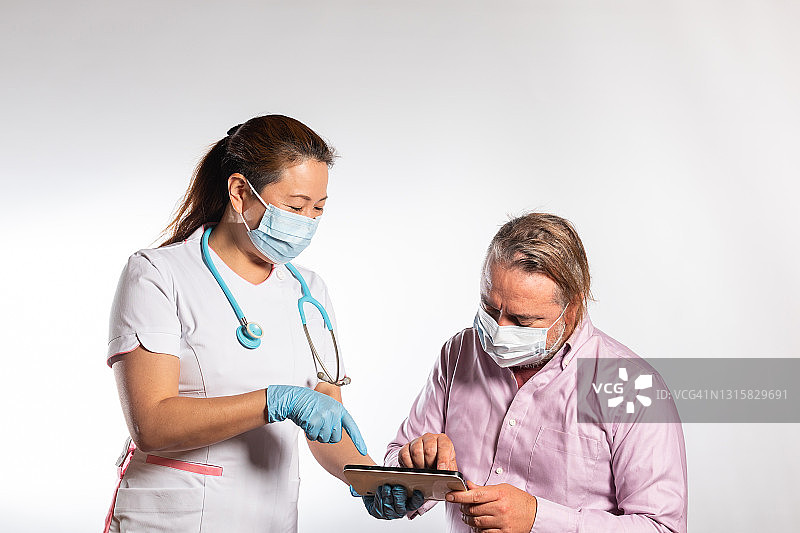 一名男子用手指在电子平板上和护士签名图片素材