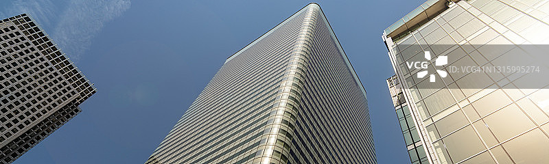 现代城市的摩天大楼在明亮的阳光下反射图片素材