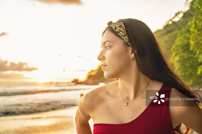 美丽的年轻女人在日落在一个热带海滩在哥斯达黎加图片素材