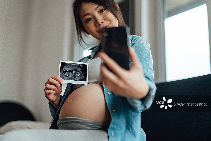 孕妇通过视频电话与家人分享胎儿超声图像图片素材