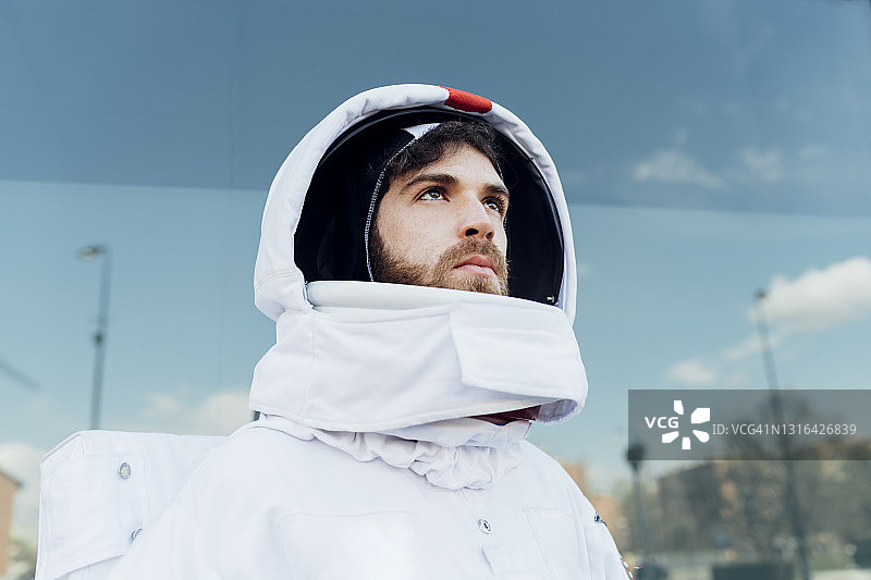 体贴的男宇航员穿着太空服看向别处的城市图片素材
