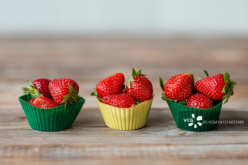 成熟的草莓躺在纸杯蛋糕模具的照片图片素材