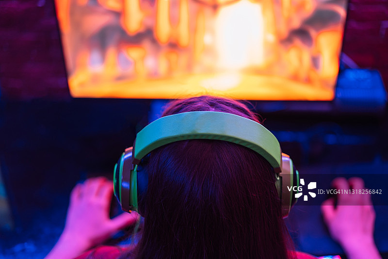 玩家女孩在霓虹灯下玩MMORPG。从上面的观点图片素材