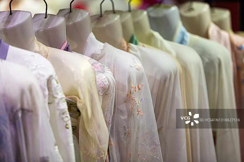 苏州丽丽古镇的商店里挂着中式丝绸衣服。中国江苏省苏州市图片素材