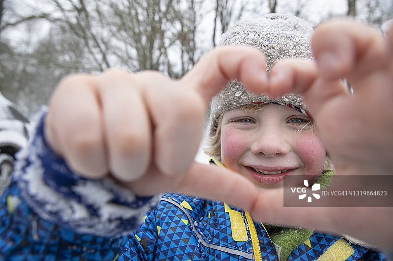 微笑的男孩在冬天用手做手势图片素材