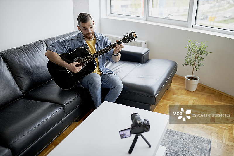 吉他手录制自己的视频，同时在卧室工作室弹奏电吉他图片素材