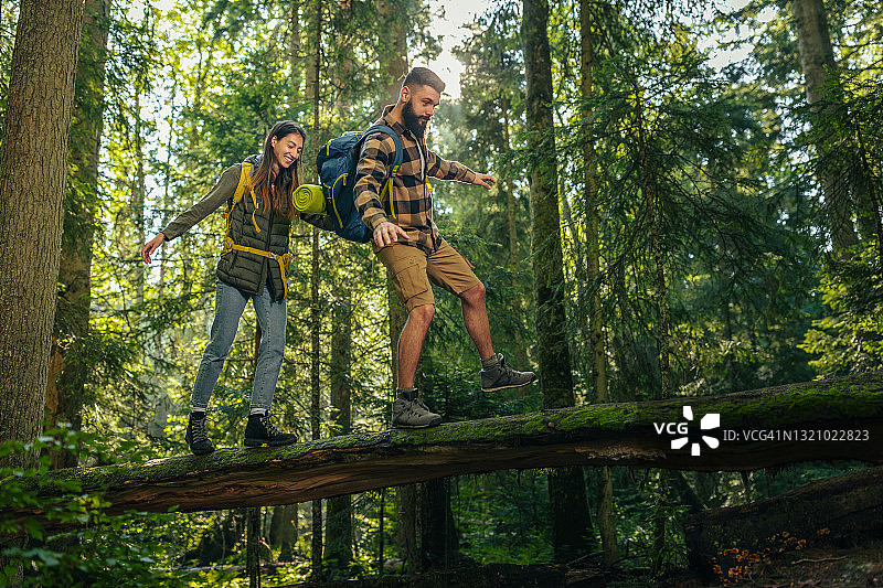 一对幸福的年轻夫妇正在森林里徒步旅行。图片素材