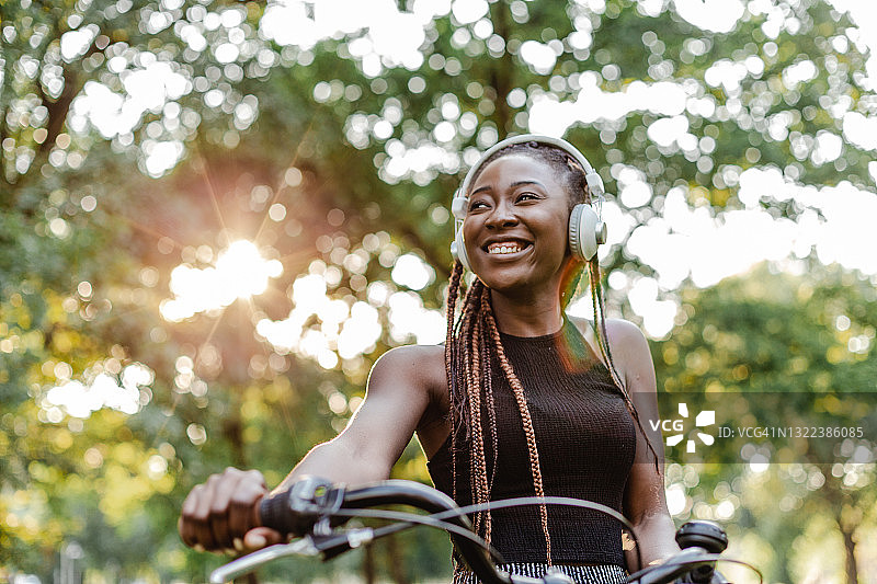 非裔美国妇女在公园里骑自行车的肖像图片素材