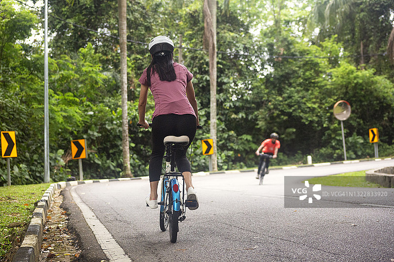 在热带雨林小径上骑自行车的休闲骑手图片素材