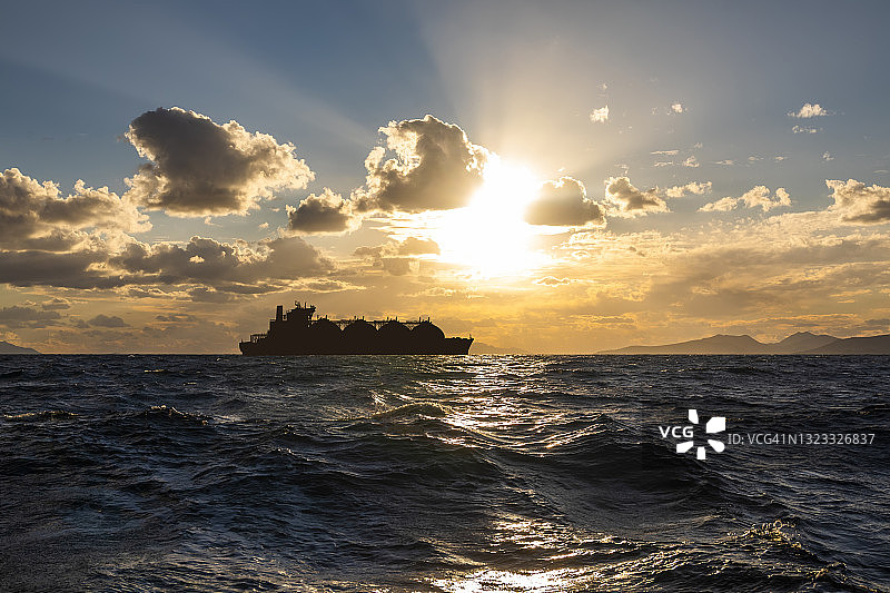 日落时分海上的液化天然气运输船。世界石油和天然气工业图片素材