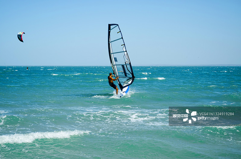 在夏日的蓝天背景下，在蓝色的大海上风筝冲浪图片素材