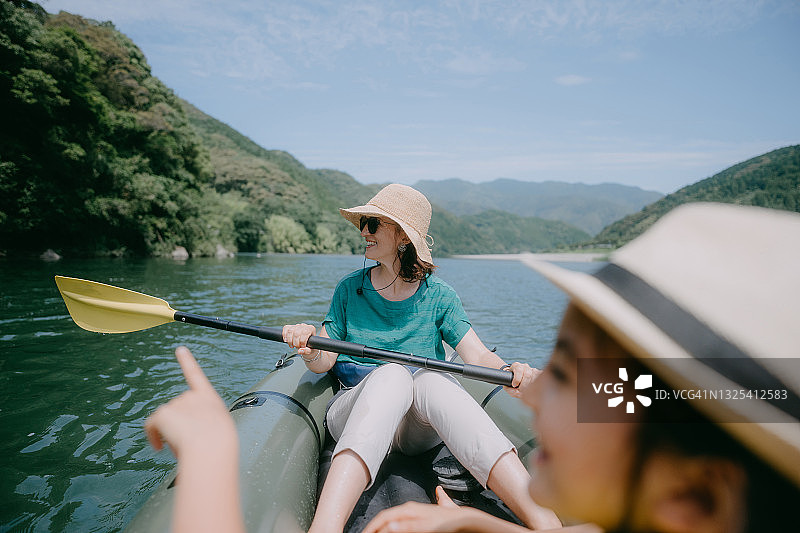 母亲皮划艇与她的孩子通过河流，日本图片素材