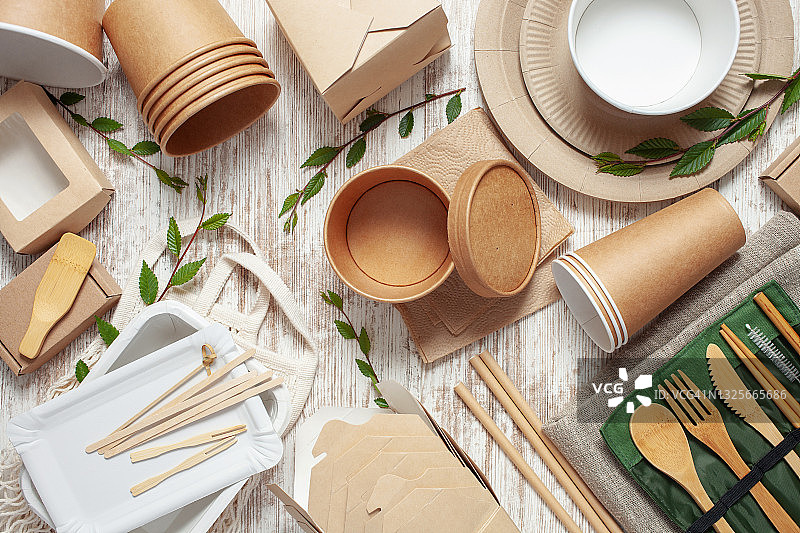生态工艺纸餐具。纸杯，盘子，袋子，快餐容器和木制餐具在粉红色的背景。回收或零废物的概念。前视图。本空间图片素材