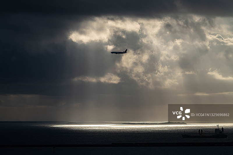 这架飞机飞过日本那霸市的日落海滩图片素材