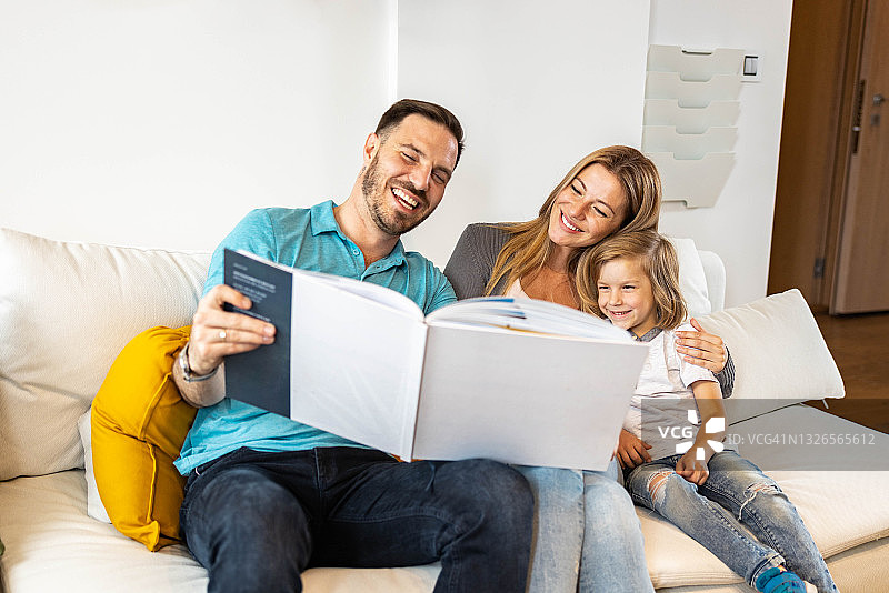 幸福一家人在家看相册。图片素材