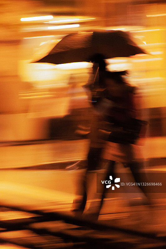 无法识别的运动模糊了在雨中行走的人图片素材