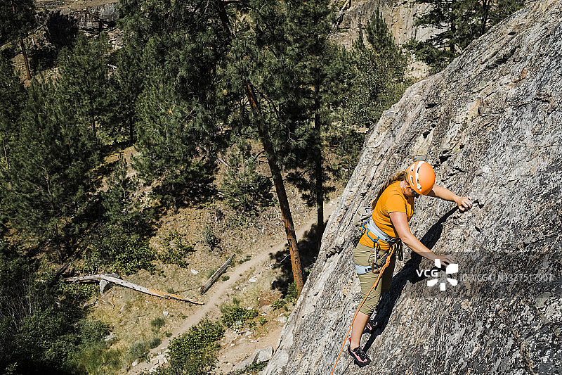 一名熟练的女性攀岩者在岩壁上用快扣扣住图片素材
