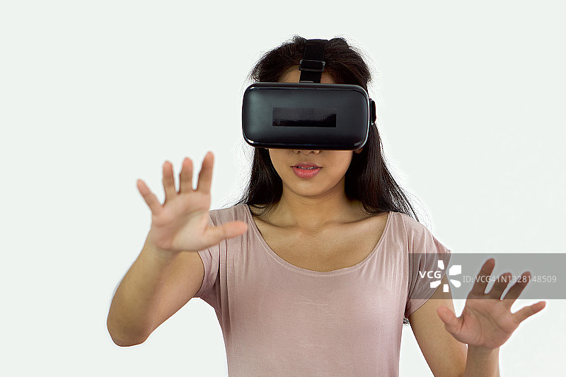 亚洲青少年使用虚拟现实眼镜，玩互动游戏。未来科技的概念。图片素材