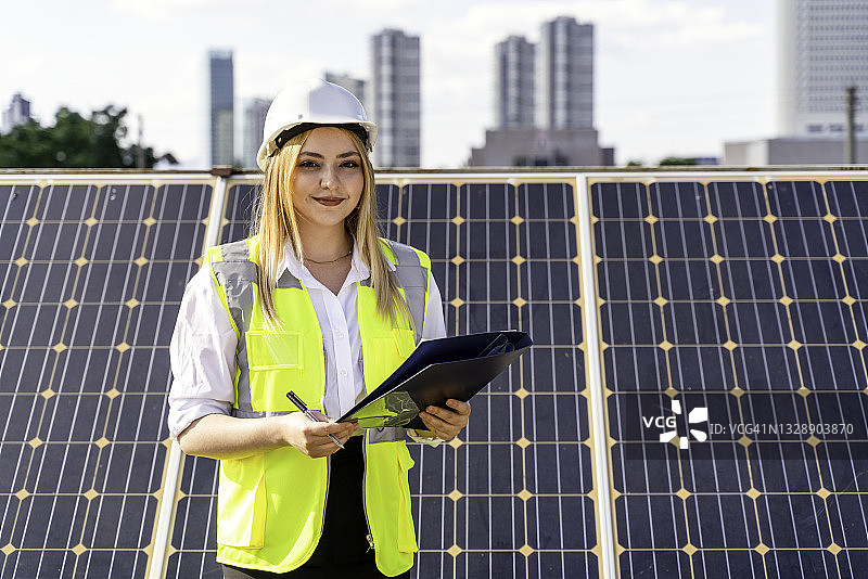 在可再生能源计划的工人，年轻女性在太阳能发电站工作图片素材