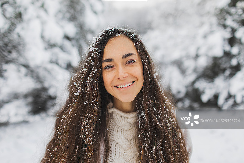 年轻漂亮的快乐女孩享受冬天和美丽的雪天。特写肖像图片素材
