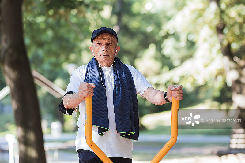 老人在公园的健身器材上锻炼图片素材