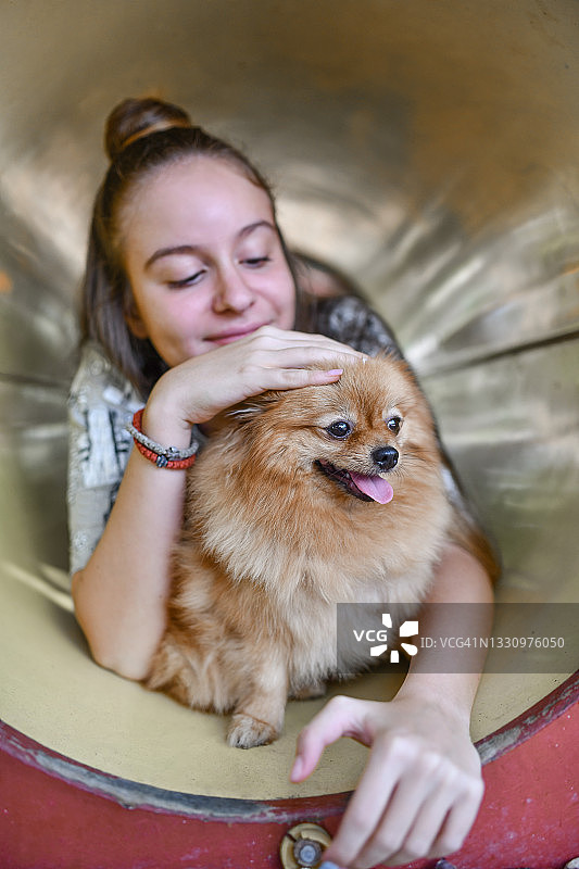 带着宠物博美犬爬过游乐场地铁的快乐时光图片素材