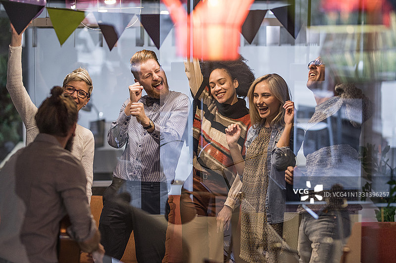 一大群快乐的企业家在办公室聚会上跳舞。图片素材