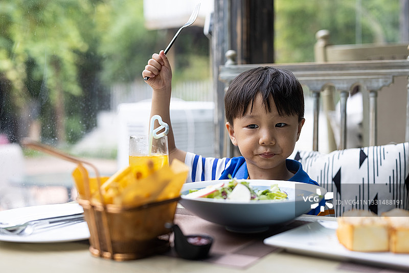 一个小男孩在餐馆吃饭图片素材