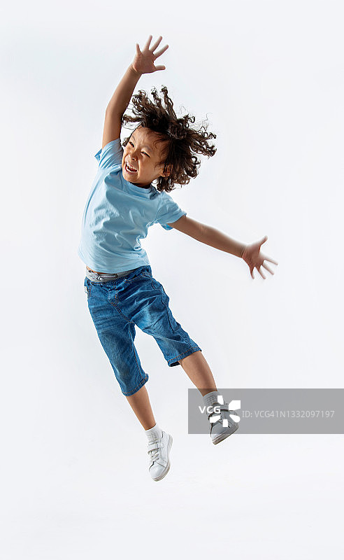小男孩在白色背景上跳跃图片素材