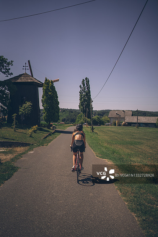 夏天，女自行车手沿着乡间小路骑行图片素材