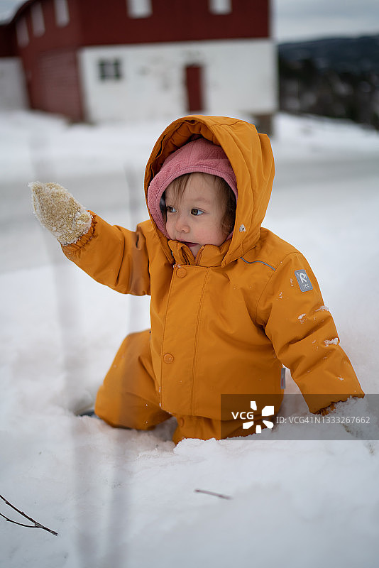 在挪威维肯，一个孩子在雪地里玩耍图片素材